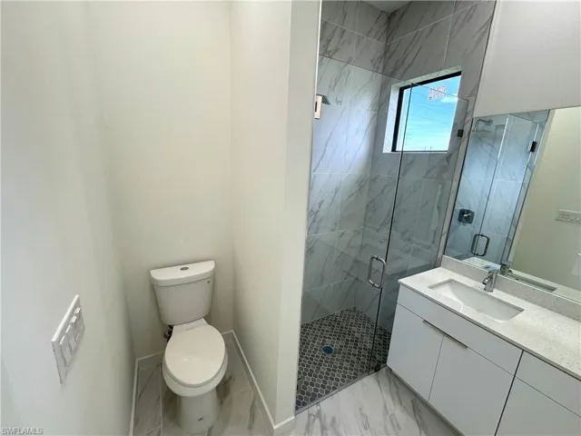 Full bath with a marble finish shower, vanity, and light marble finish floors