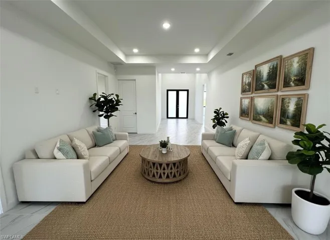 Living area with recessed lighting and a raised ceiling