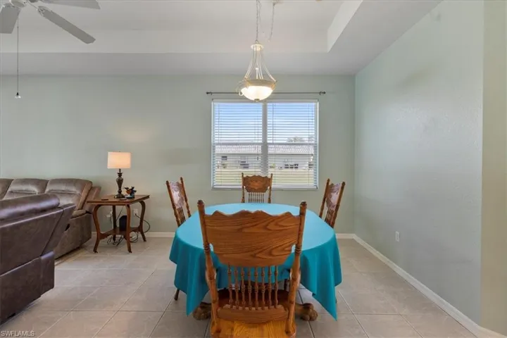 Tiled dining room featuring ceiling fan