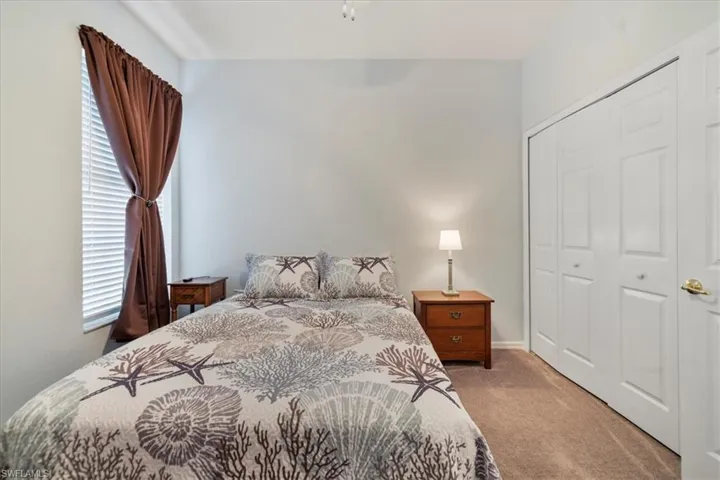 Bedroom featuring light colored carpet and a closet