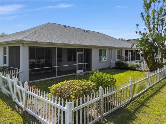 Back of house with a sunroom and a lawn