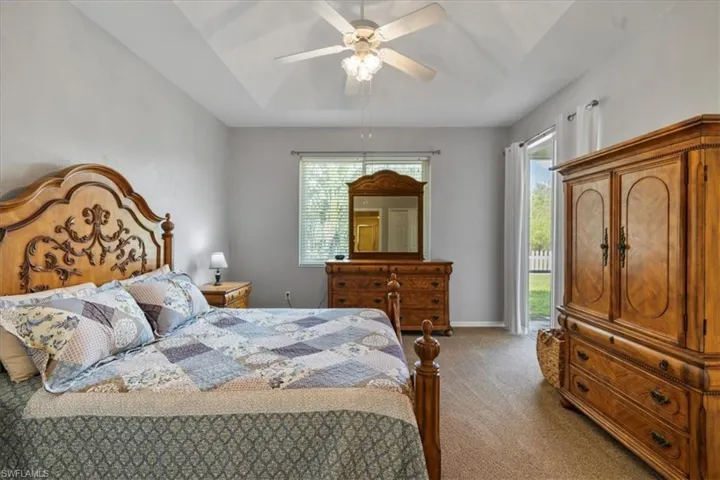 Carpeted bedroom with ceiling fan and access to outside