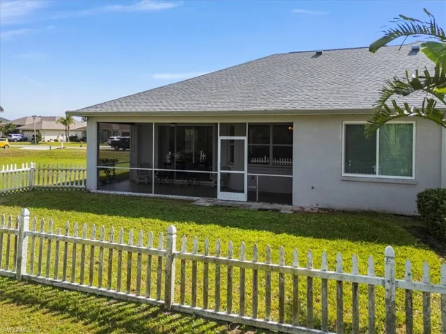 Back of house with a lawn and a sunroom