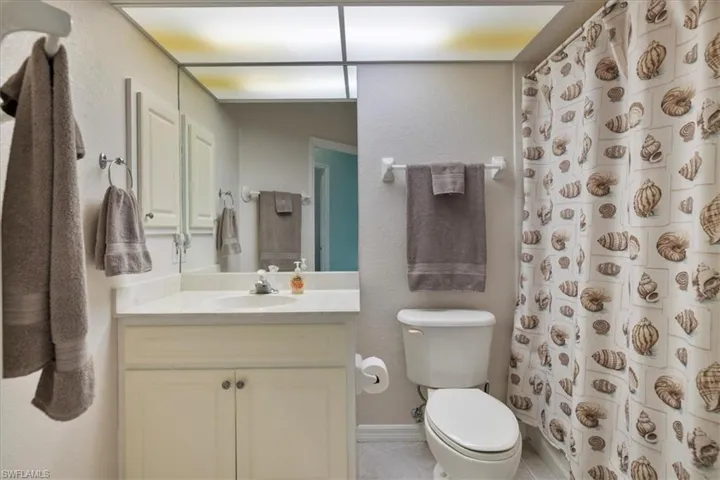 Bathroom with vanity, a shower with curtain, and toilet