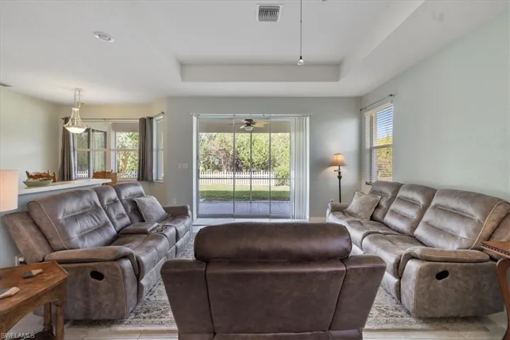Living room featuring a tray ceiling and ceiling fan