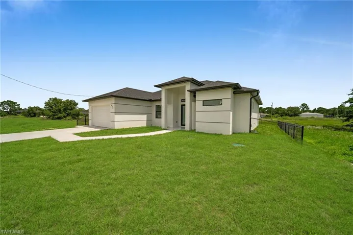 View of front of property with driveway, stucco siding, and a garage