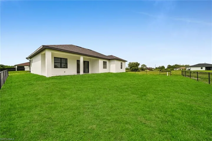 Back of property featuring a fenced backyard and stucco siding