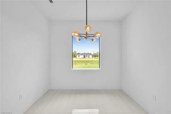 Empty room with a chandelier and baseboards