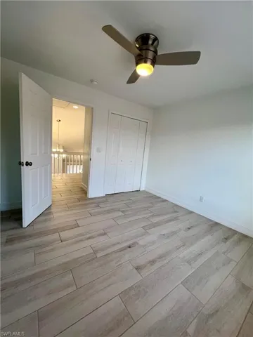 Unfurnished bedroom featuring wood tiled floors, ceiling fan, and a closet