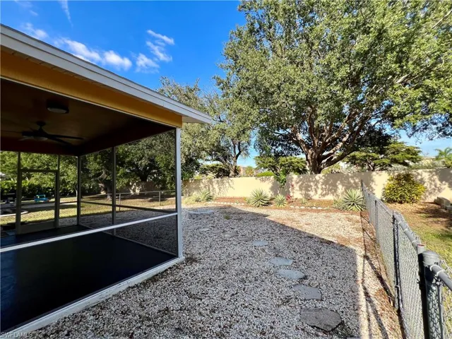 Fenced backyard featuring a ceiling fan and a sunroom