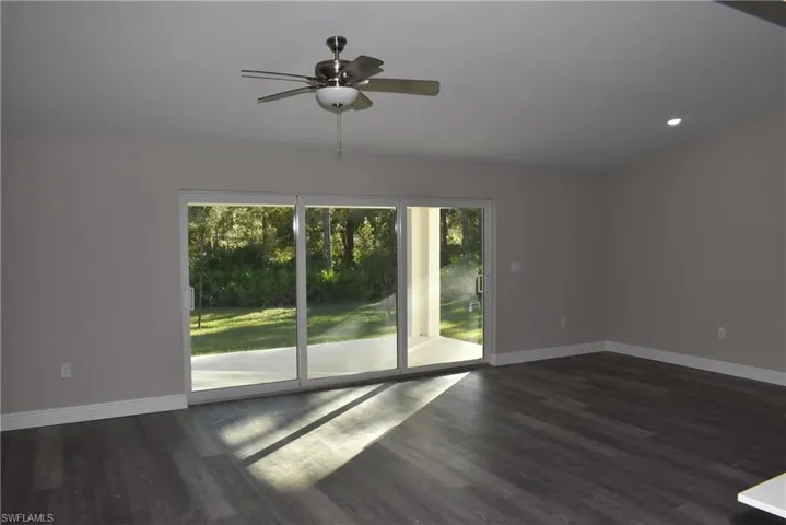 Spare room with ceiling fan and dark wood-type flooring