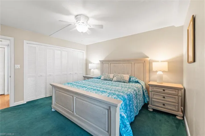 Bedroom featuring a closet, ceiling fan, and dark colored carpet