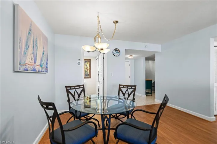 Dining area with light wood-style floors and hanging lights
