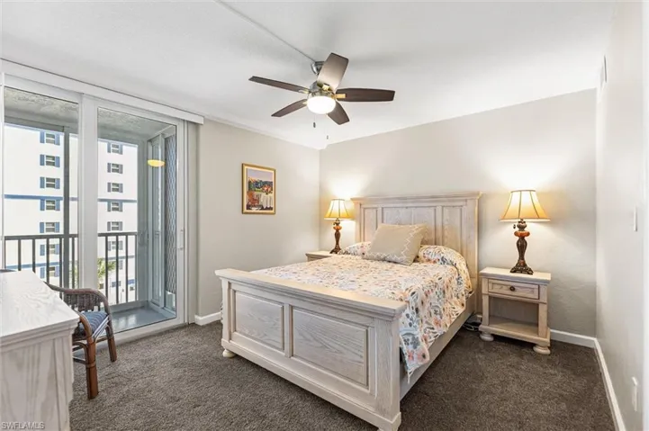 Bedroom with access to outside, a ceiling fan, dark carpet, and ornamental molding