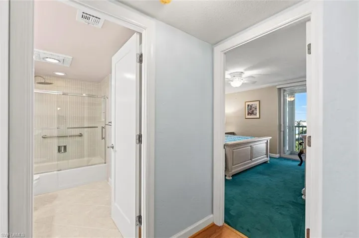 Hall with a textured ceiling and light colored carpet