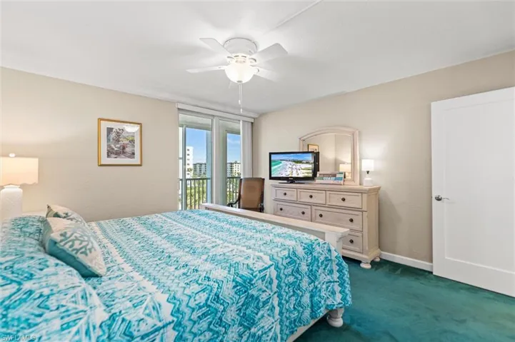 Bedroom with access to outside, dark colored carpet, and ceiling fan