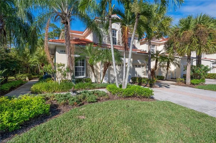 Mediterranean / spanish home with driveway, stucco siding, a front lawn, a tiled roof, and an attached garage