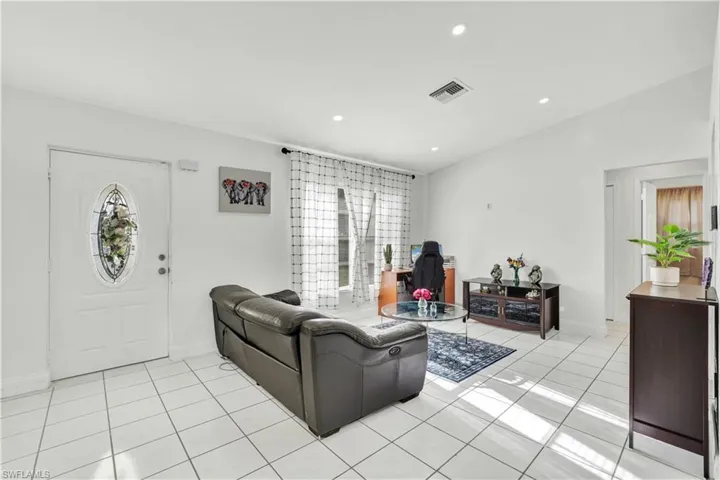Living room featuring light tile patterned flooring and recessed lighting