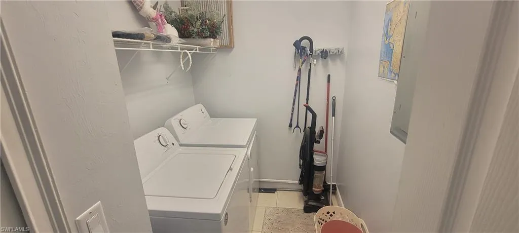 Utility area featuring a washer and dryer, wire shelving, and light-toned wall paint