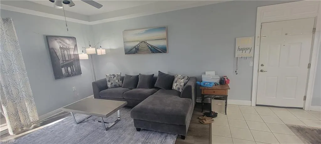 Living area featuring a ceiling fan, crown molding, and light gray wall tones