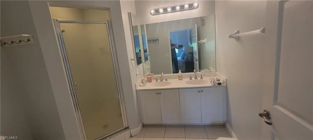 Bathroom featuring a double vanity with white cabinetry, light-toned countertop, and dual undermount sinks