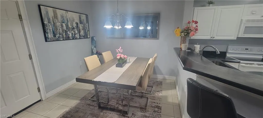 Dining area with tile flooring and a contemporary chandelier