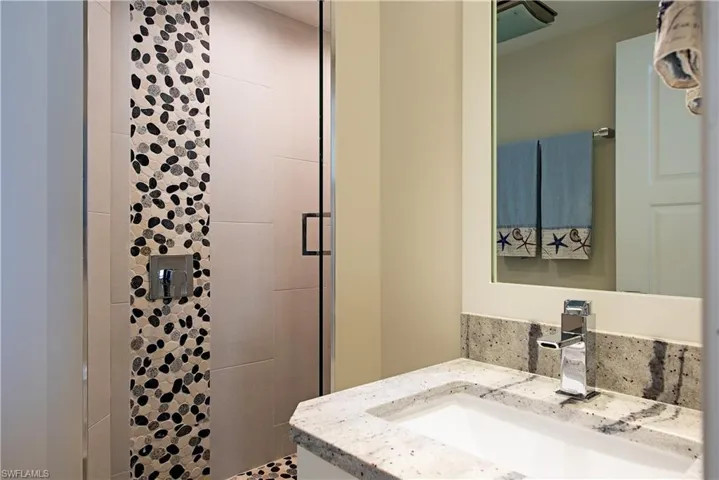 Full bathroom for the two guest bedrooms featuring a shower stall and vanity
