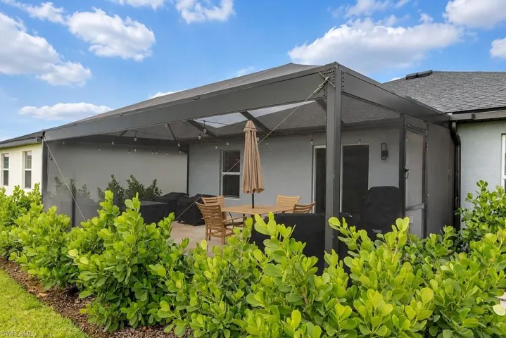Screened-in patio featuring a concrete slab, string lighting, and direct access to the interior