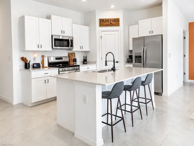 Modern kitchen featuring white cabinetry, stainless steel appliances, and light-toned countertops