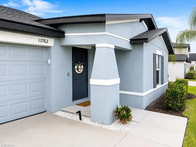 Exterior featuring a muted blue stucco finish and dark gray trim