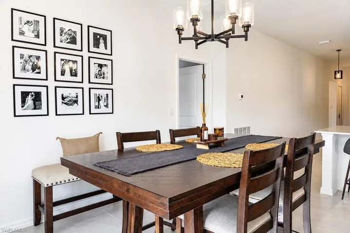 Dining area featuring a dark wood finish table, complementary upholstered seating, and a modern industrial-style chandelier