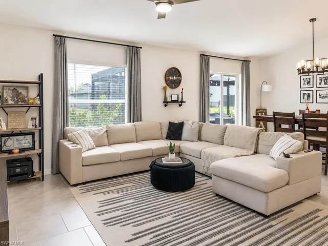 Expansive living area featuring large format tile flooring, a modern ceiling fan, and abundant natural light from multiple windows