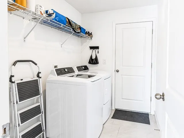 Dedicated laundry area featuring a top-load washing machine and a front-load dryer