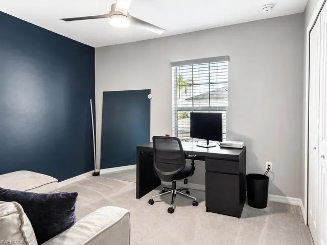 Carpeted room featuring a modern ceiling fan with integrated lighting, a window with horizontal blinds, and bi-fold closet doors