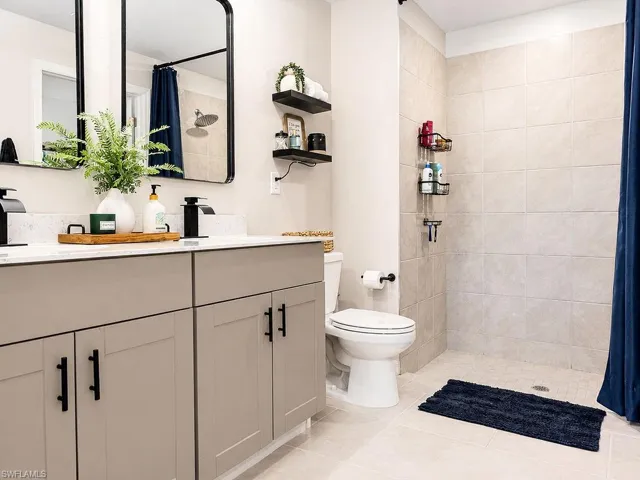 Double vanity with white countertop, undermount sinks, and matte black fixtures