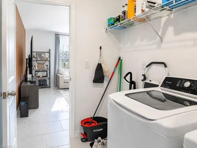 Dedicated laundry area featuring white walls and a white wire shelf
