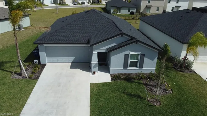 Modern single-story residence featuring a blue exterior, dark shingle roof, and an attached garage