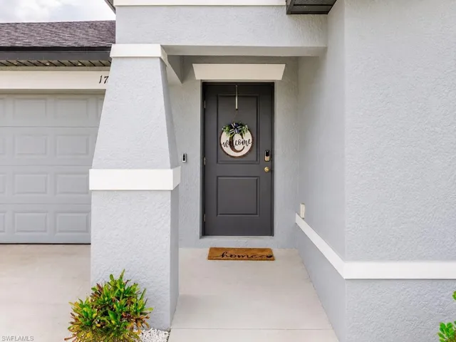Inviting front entrance with a dark gray door and stucco exterior