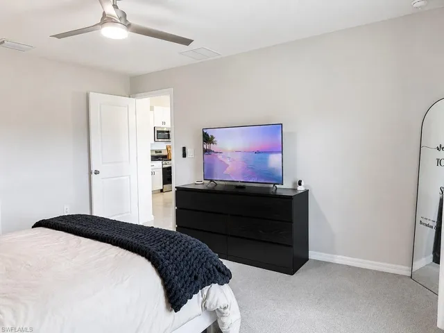 Bedroom with light gray carpeting and a contemporary ceiling fan with integrated lighting
