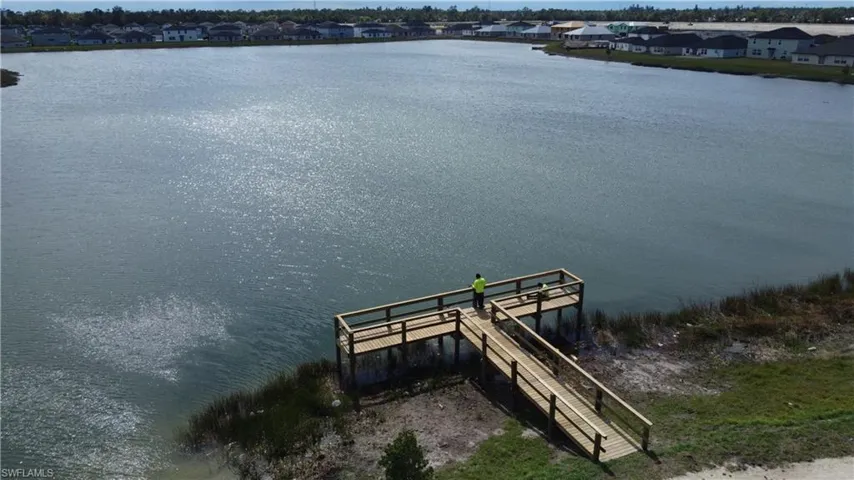 Expansive lakefront property featuring a newly constructed wooden dock and ramp