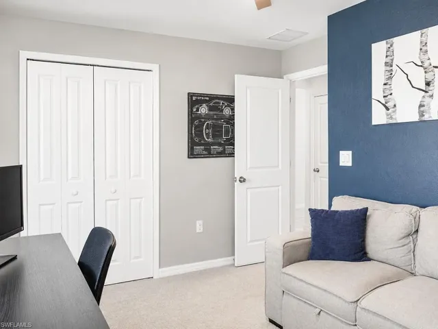 Carpeted room featuring a white bi-fold closet, a white panel door, and two-tone wall finishes
