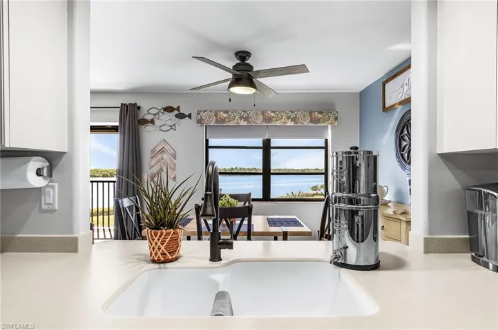 Kitchen featuring white cabinetry, a ceiling fan, and a water view