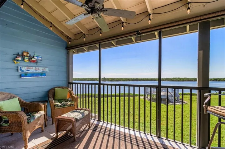 Sunroom / solarium with a water view, lofted ceiling, a ceiling fan, and track lighting