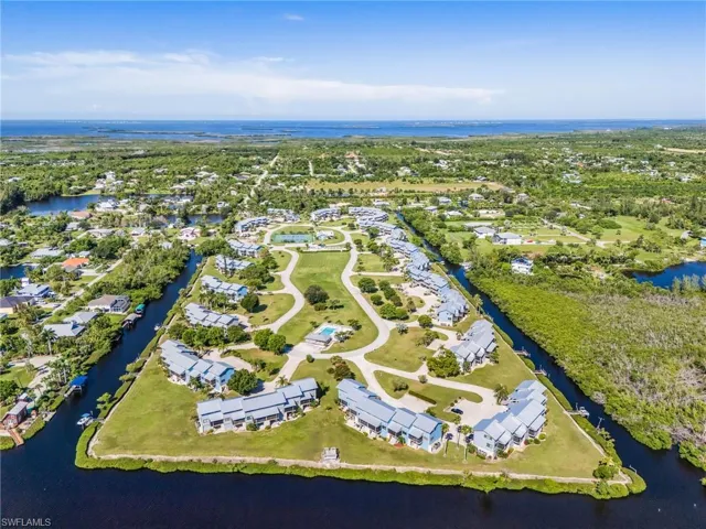 Aerial view of property and surrounding area with a large body of water and nearby suburban area