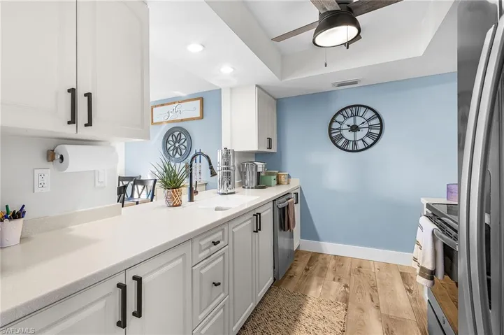 Kitchen with white cabinets, stainless steel appliances, light wood-type flooring, recessed lighting, and a ceiling fan