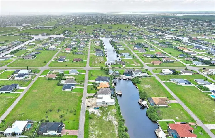 Aerial view of property and surrounding area with a nearby body of water and nearby suburban area