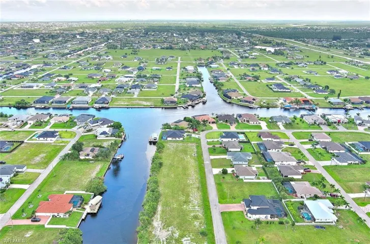 Aerial view of property's location with nearby suburban area and a nearby body of water