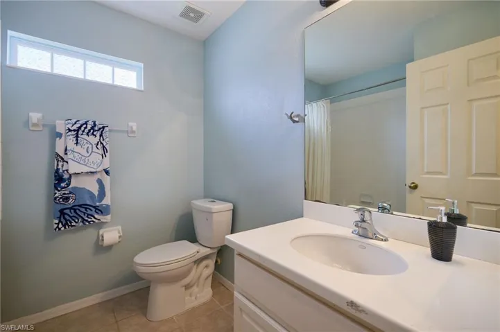 Bathroom featuring a single vanity with an integrated sink, polished chrome faucet, and a large wall-mounted mirror