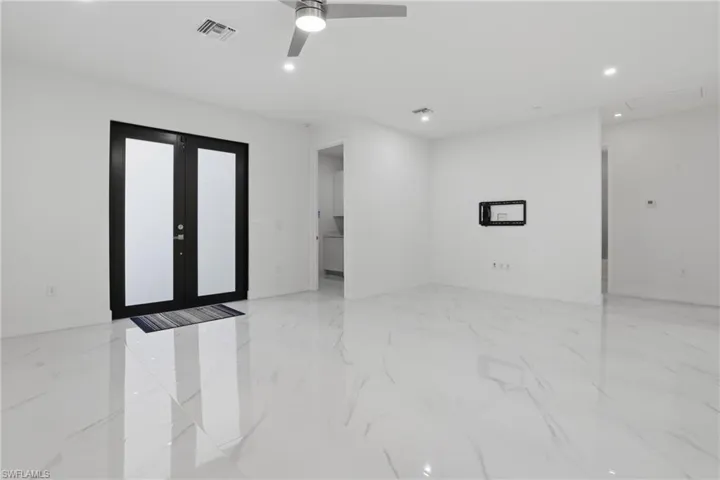 Spacious room featuring large format tile flooring, recessed lighting, and a modern ceiling fan