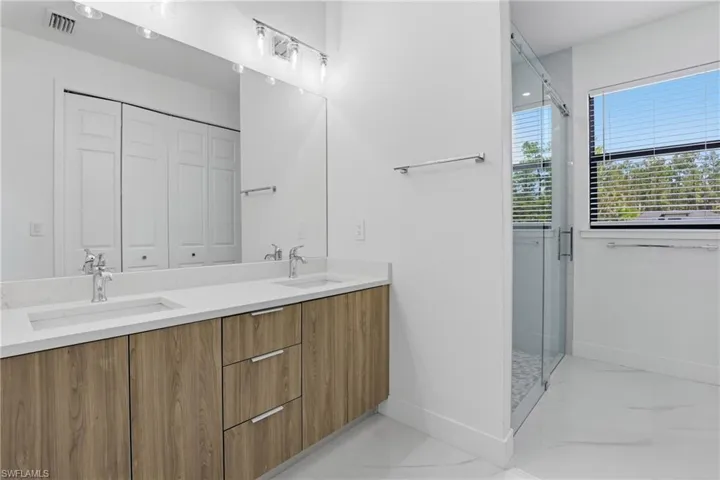 Dual vanity with wood-finish cabinetry and white countertops